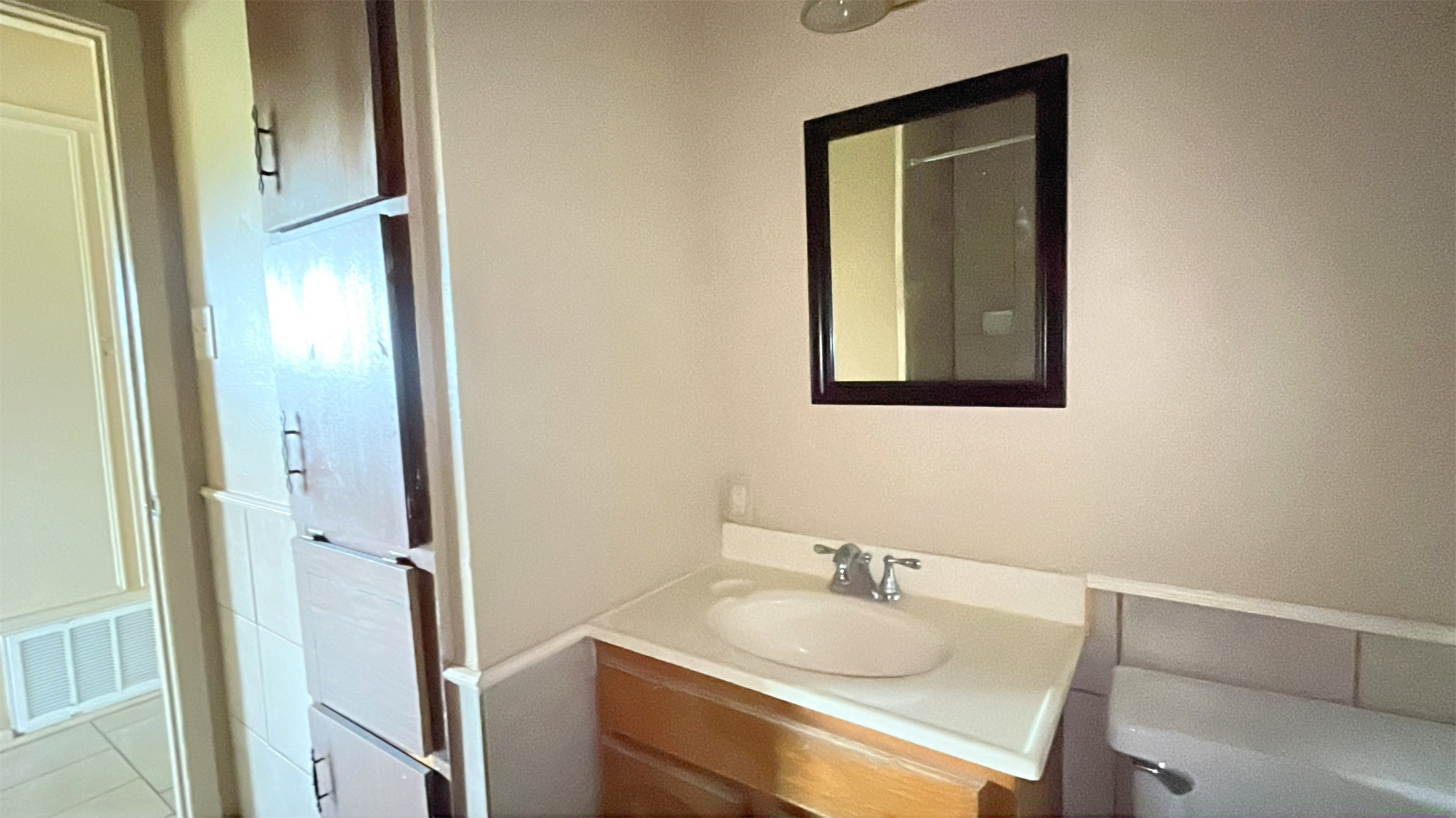 3021 Sycamore Avenue, Unit 1 Bay City, TX 77414 - Photo 8 of 9 a bathroom with a granite countertop sink and a mirror