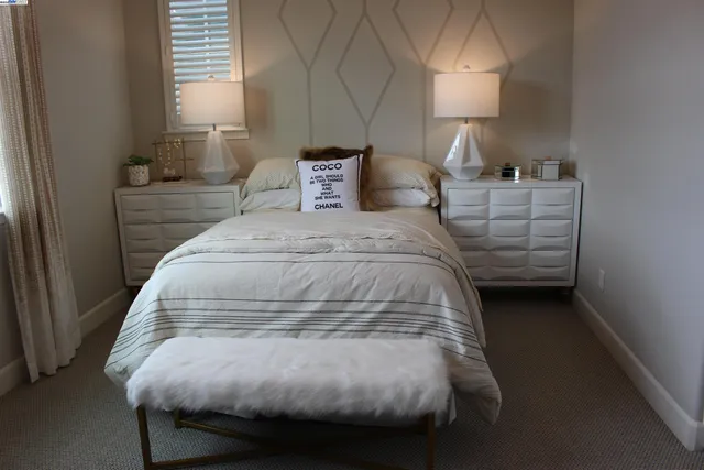 a bedroom with a bed and a painting on the wall