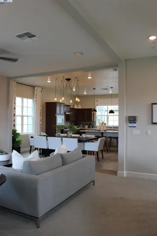 a kitchen with stainless steel appliances a kitchen island a stove a table and a sink