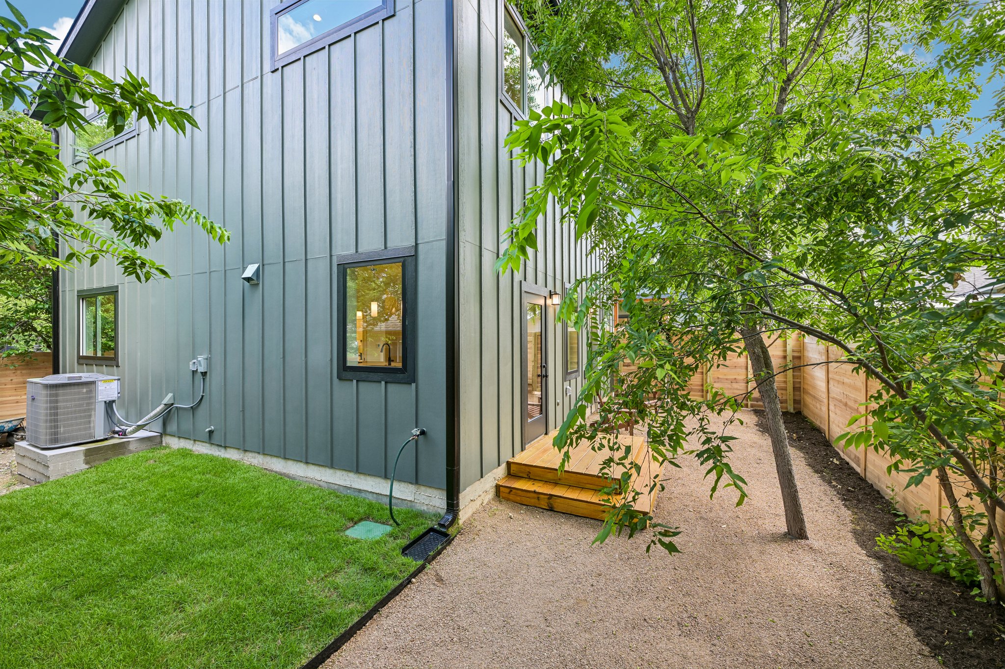 513 West Odell Street, Unit B Austin, TX 78752 - Photo 34 of 38 A private backyard oasis with mature trees, grass, and a fenced-in yard for tranquil outdoor living.