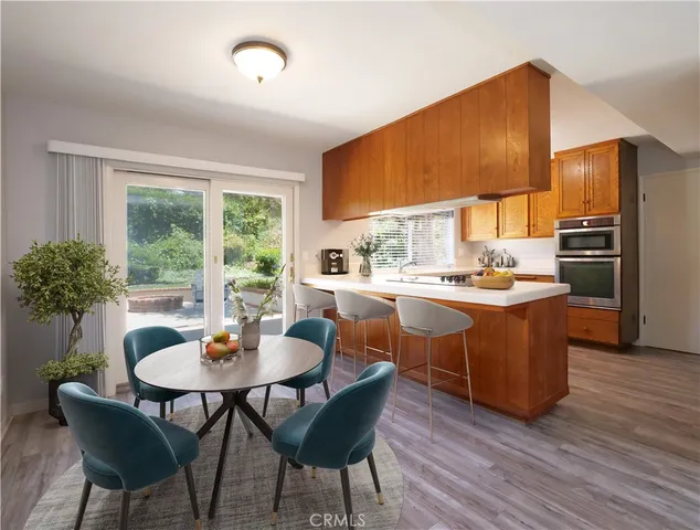 a kitchen with stainless steel appliances wooden cabinets and a wooden floor
