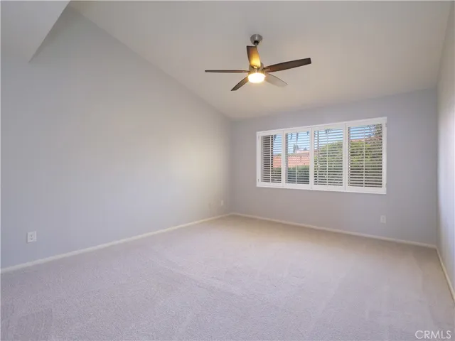 an empty room with fan and windows