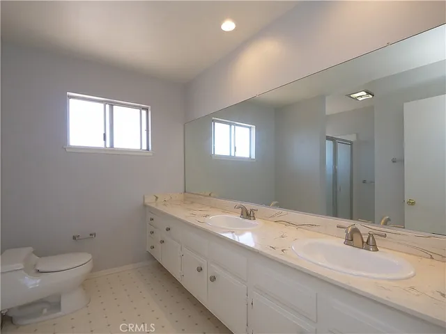 a bedroom with a large bed and a potted plant
