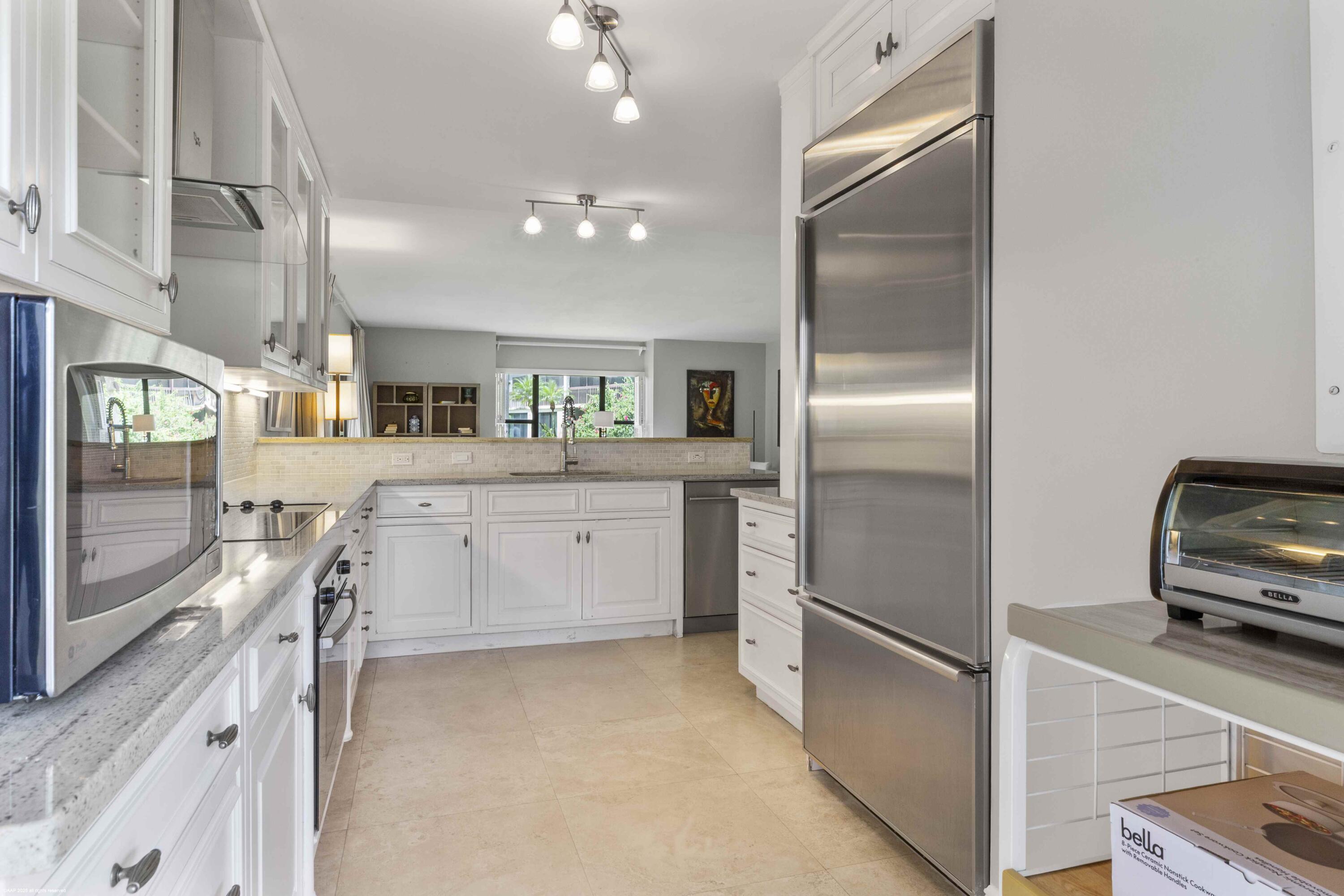 13329 Polo Club Road, Unit 105 Wellington, FL 33414 - Photo 12 of 43 a kitchen with stainless steel appliances a refrigerator sink and stove