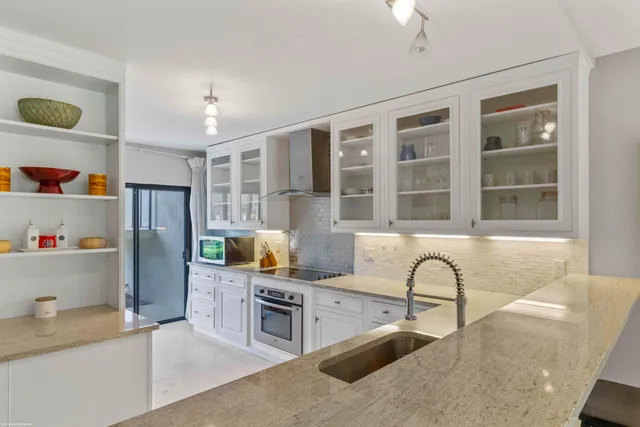 a kitchen with stainless steel appliances granite countertop a refrigerator and a stove top oven
