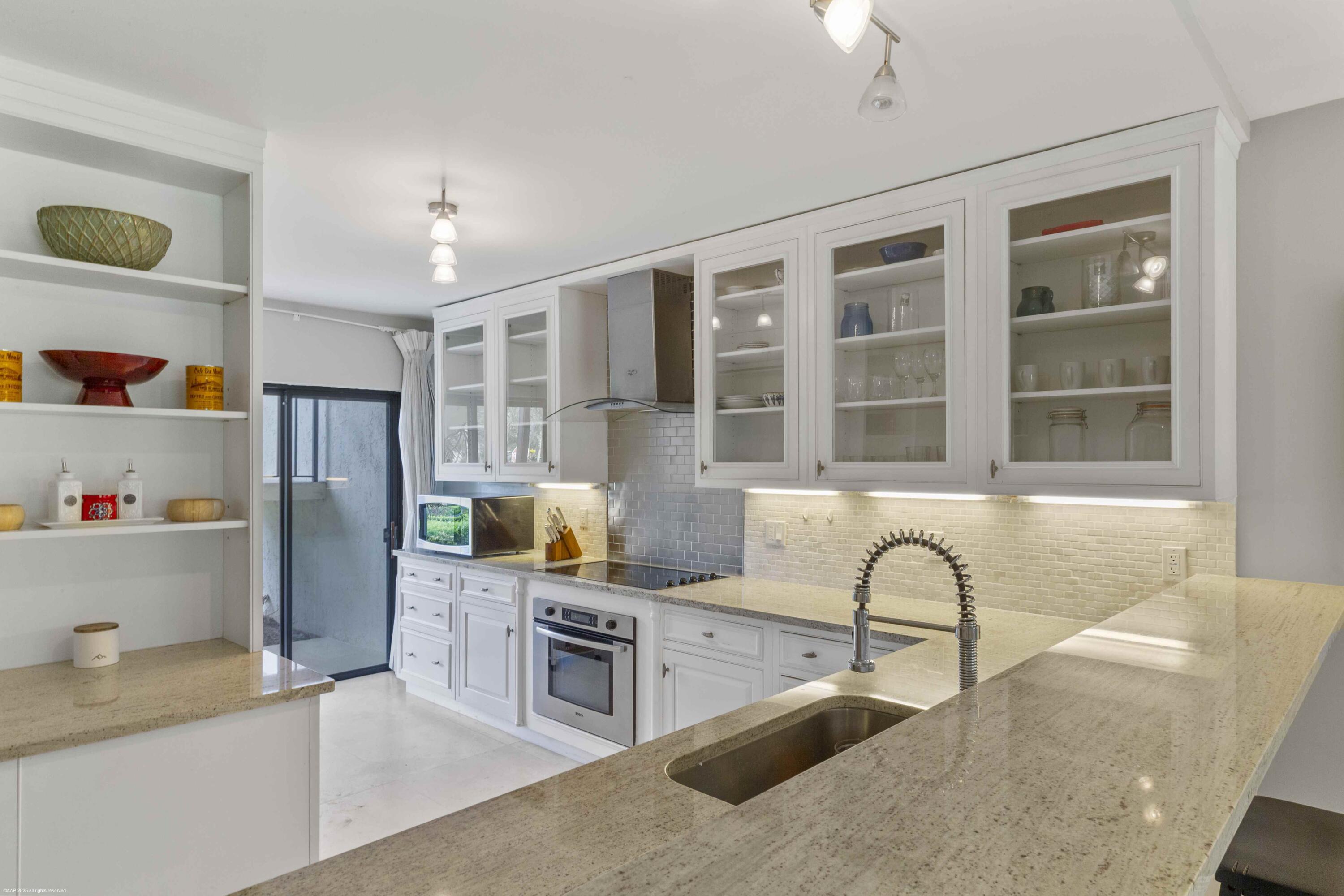 13329 Polo Club Road, Unit 105 Wellington, FL 33414 - Photo 13 of 43 a kitchen with stainless steel appliances granite countertop a refrigerator and a stove top oven