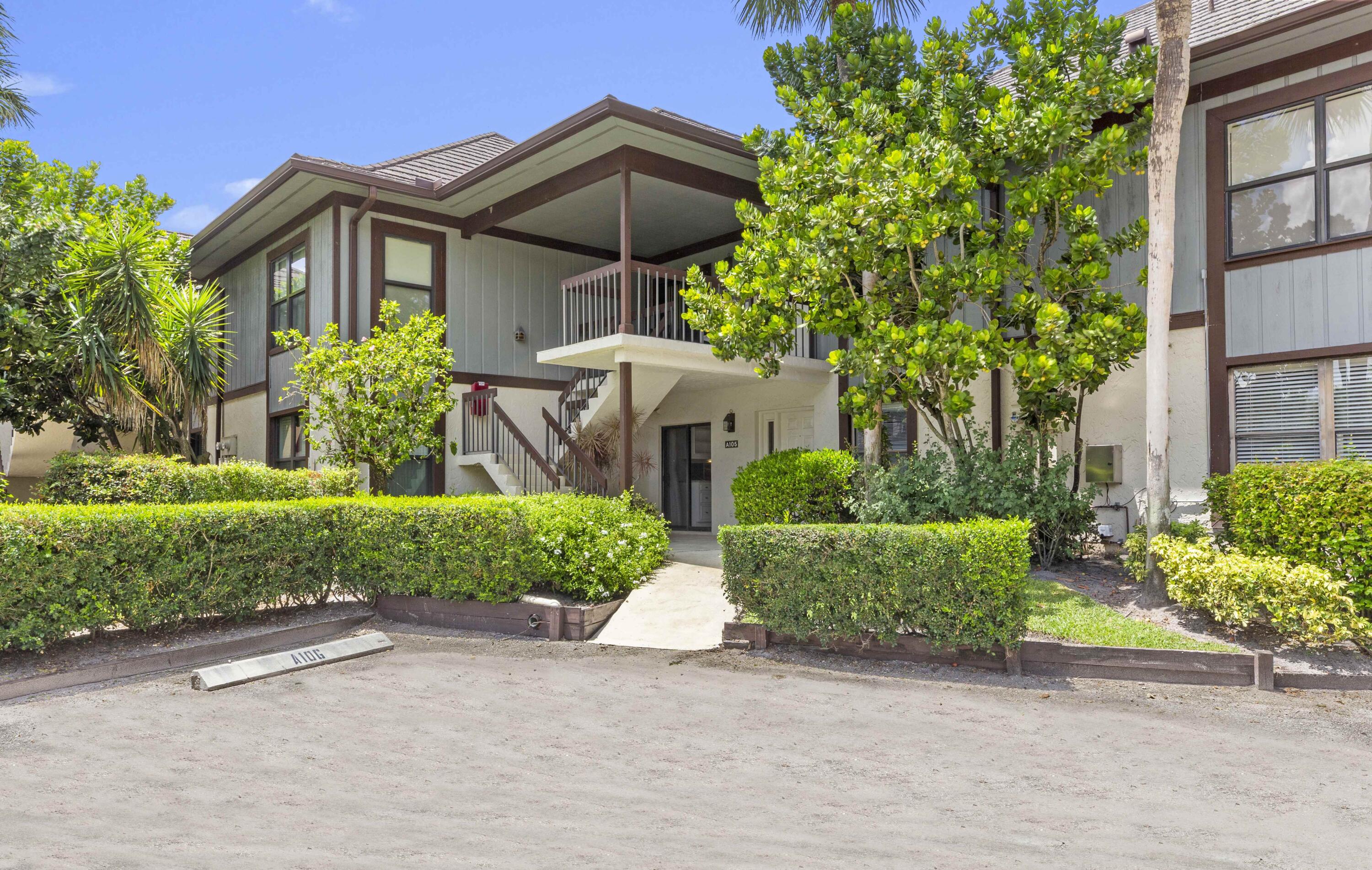 13329 Polo Club Road, Unit 105 Wellington, FL 33414 - Photo 5 of 43 a front view of a house with a garden