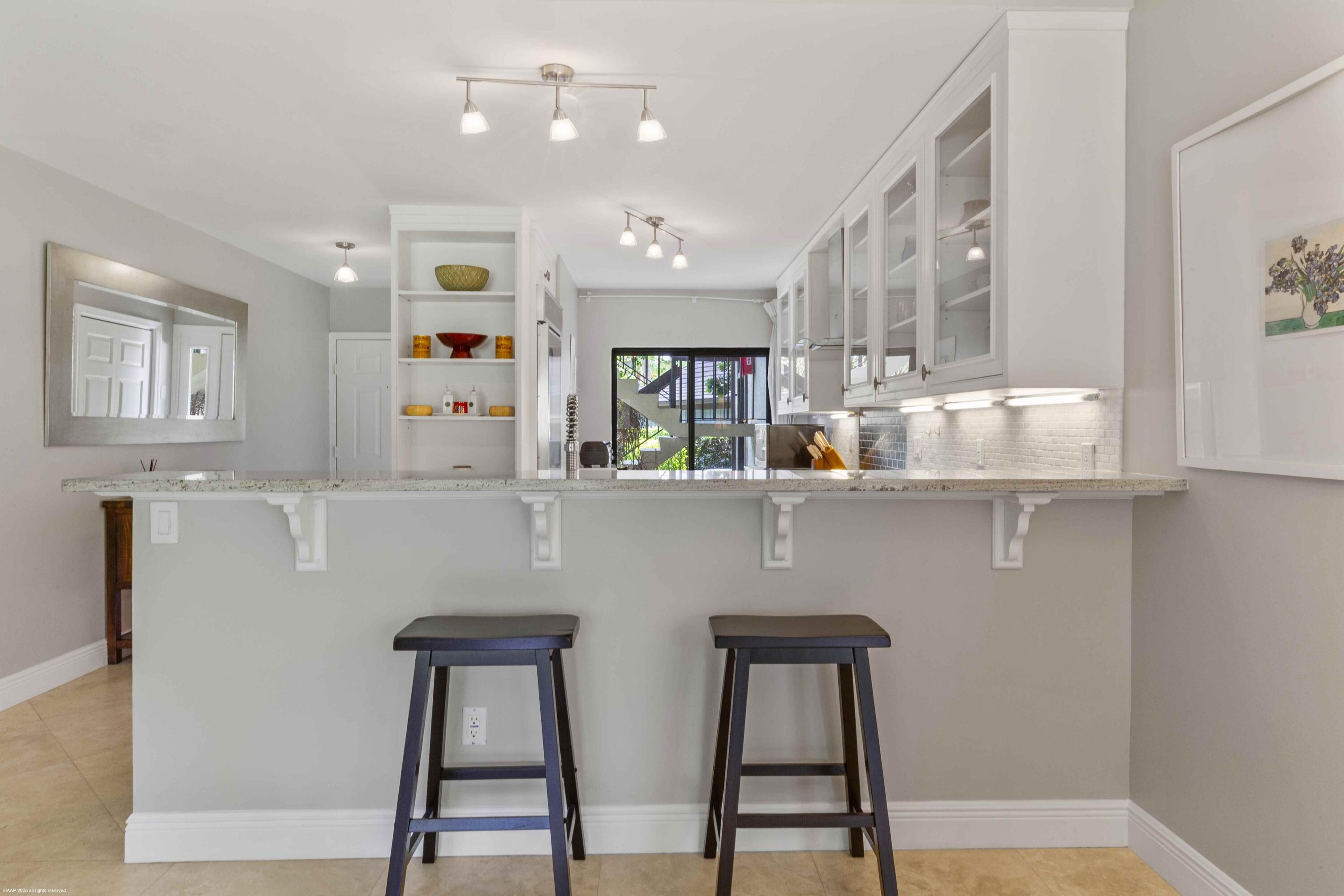 13329 Polo Club Road, Unit 105 Wellington, FL 33414 - Photo 10 of 43 a kitchen with stainless steel appliances granite countertop a sink a window and white cabinets