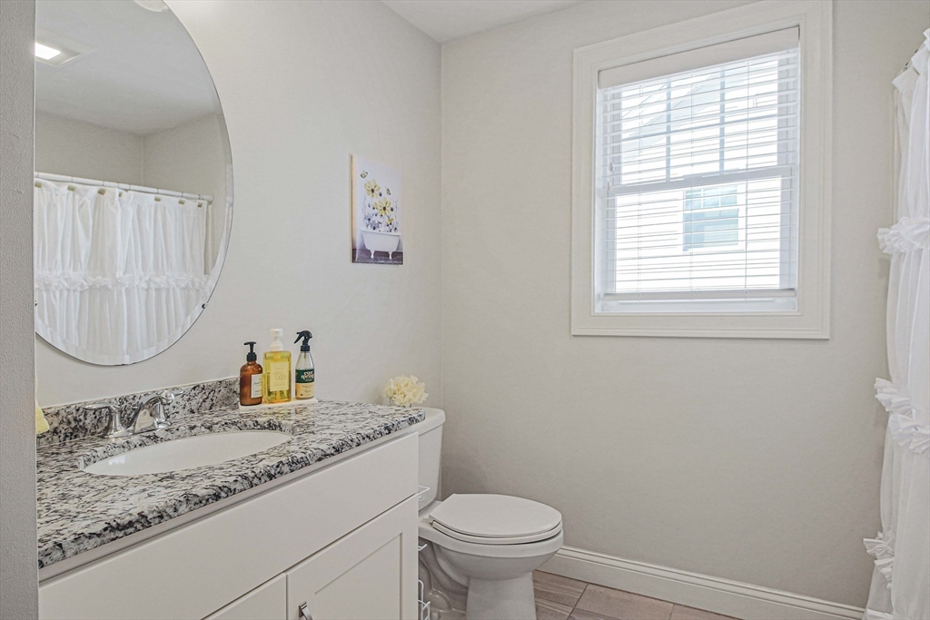 831 Ledgewood Way, Unit 831 Clinton, MA 01510 - Photo 16 of 41 a bathroom with a granite countertop sink toilet and a mirror