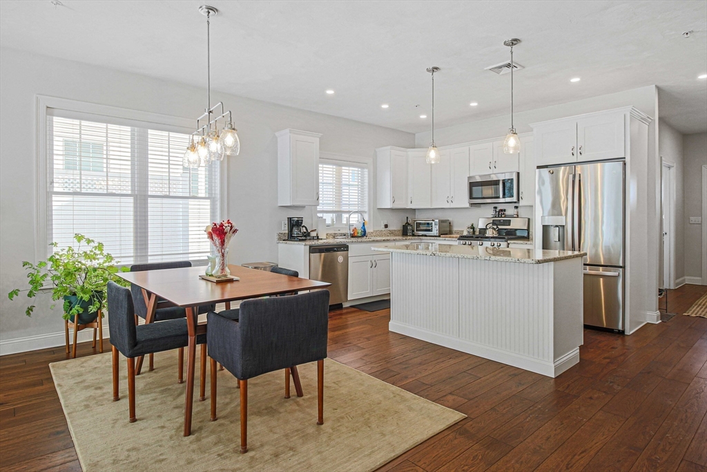 831 Ledgewood Way, Unit 831 Clinton, MA 01510 - Photo 26 of 41 a kitchen with kitchen island a dining table and chairs