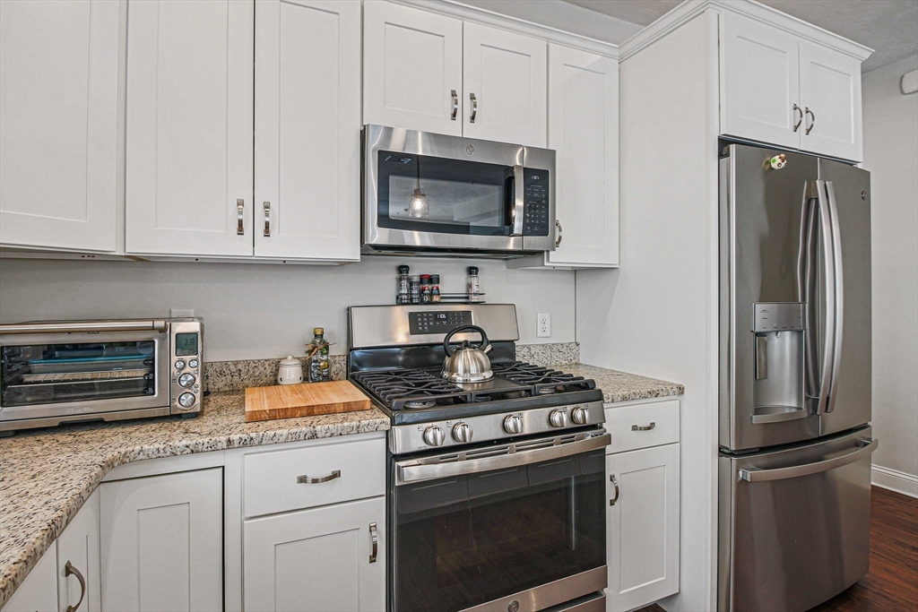831 Ledgewood Way, Unit 831 Clinton, MA 01510 - Photo 30 of 41 a kitchen with stainless steel appliances granite countertop a stove a refrigerator and a microwave