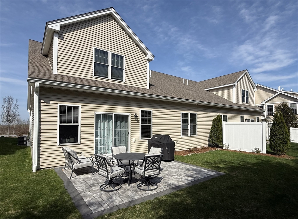 831 Ledgewood Way, Unit 831 Clinton, MA 01510 - Photo 35 of 41 a backyard of a house with table and chairs