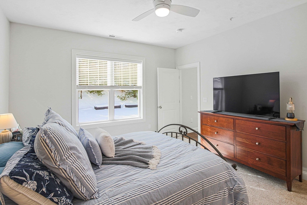 831 Ledgewood Way, Unit 831 Clinton, MA 01510 - Photo 4 of 41 a bedroom with a bed and a flat screen tv