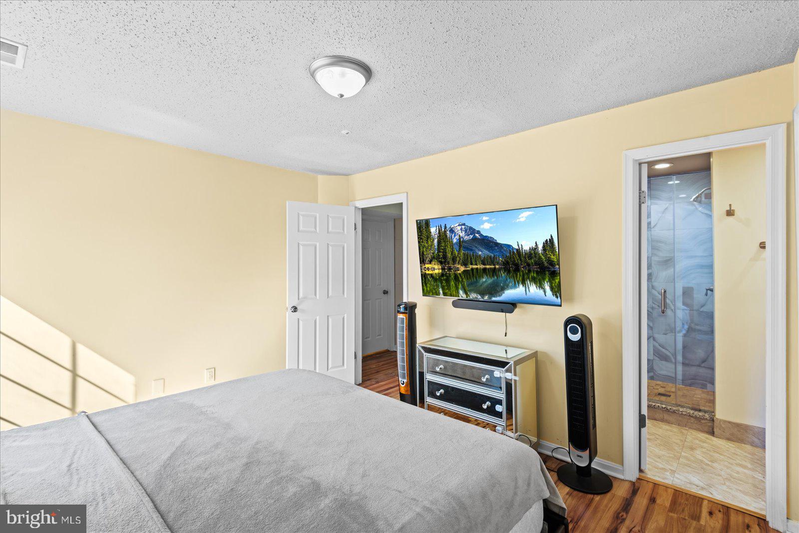 6000 F Mersey Oaks Way, Unit 1F Alexandria, VA 22315 - Photo 13 of 35 a bedroom with a bed and a flat screen tv
