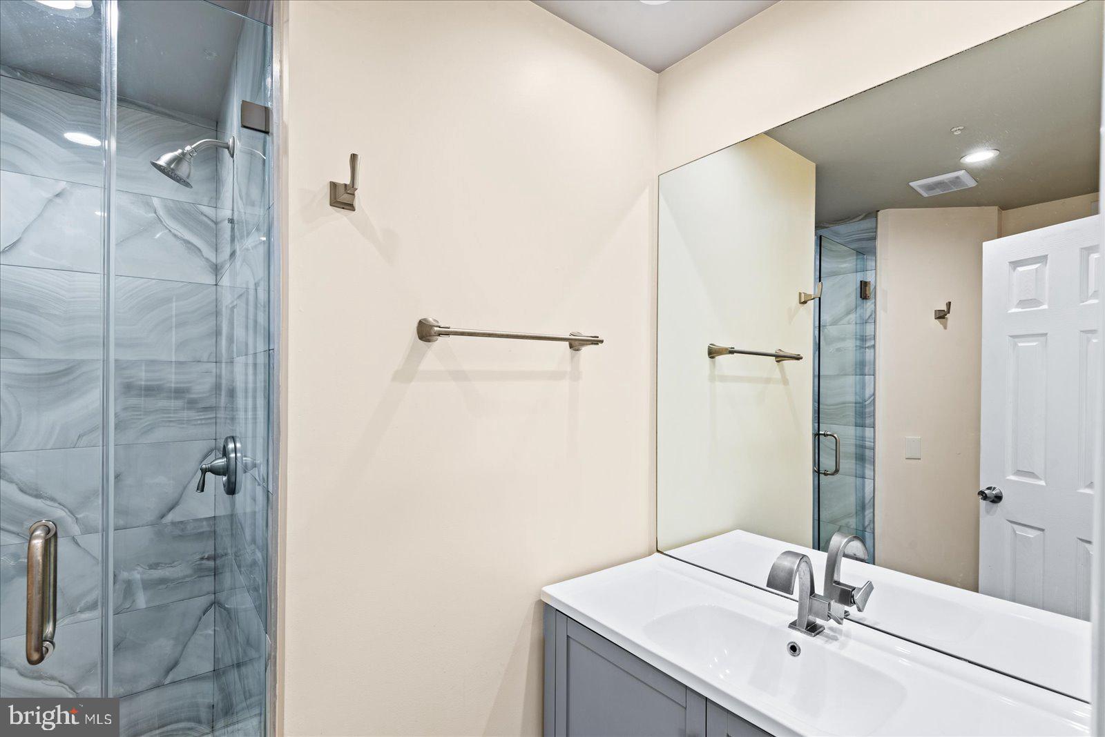 6000 F Mersey Oaks Way, Unit 1F Alexandria, VA 22315 - Photo 15 of 35 a bathroom with a sink and a mirror