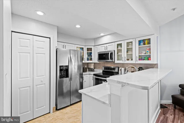 a kitchen with stainless steel appliances a refrigerator sink and microwave