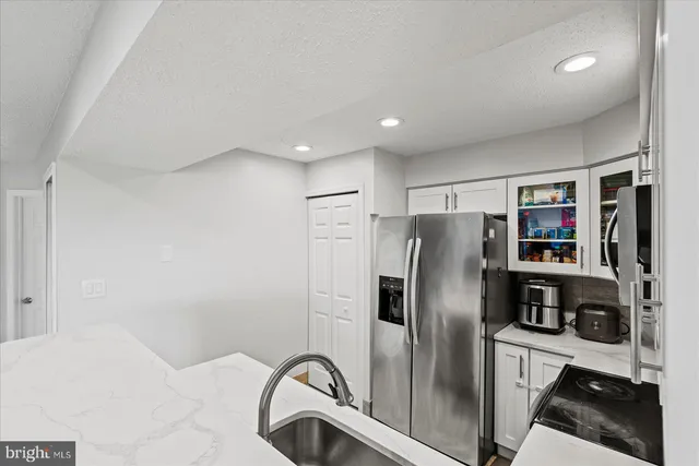 a metallic refrigerator freezer sitting in a kitchen