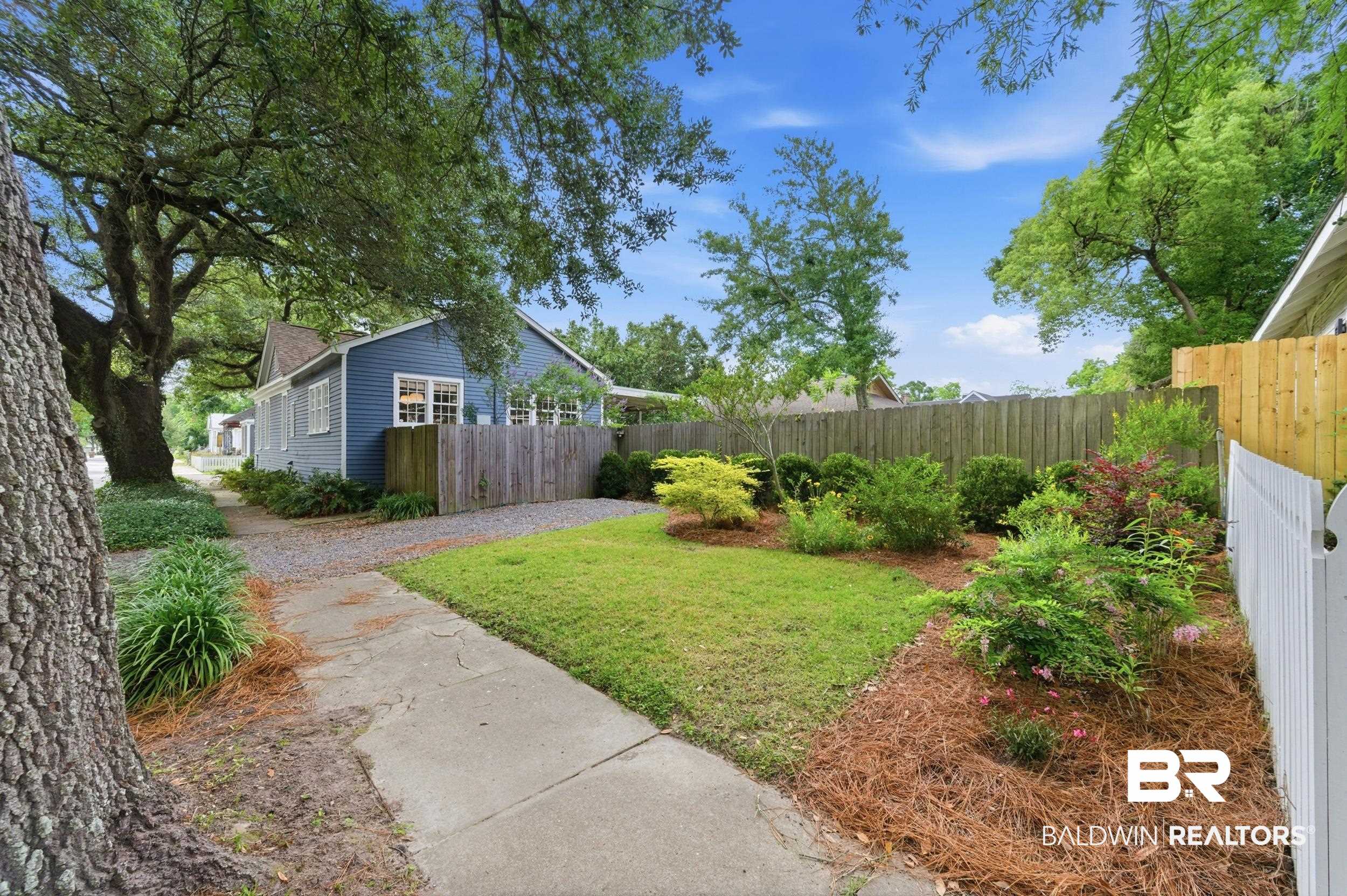 350 Charles Street Mobile, AL 36604 - Photo 36 of 52 Blue siding exterior with white window trim and a partial white picket fence