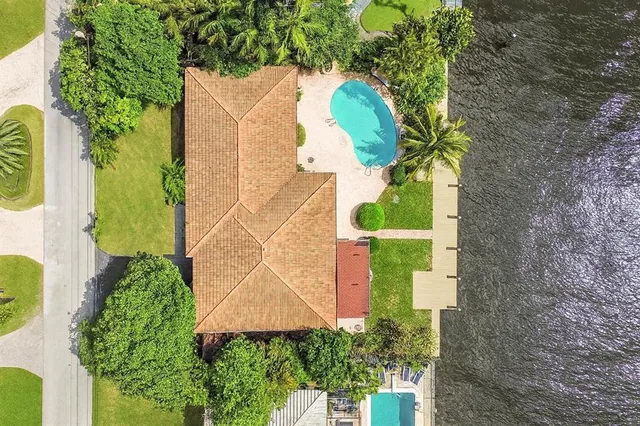 an aerial view of a house with a yard and swimming pool