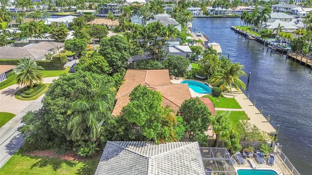an aerial view of residential houses with outdoor space and trees