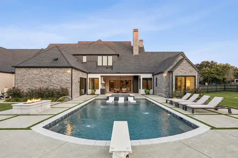 a view of a house with pool and chairs
