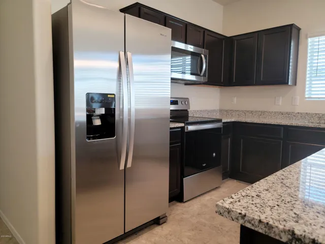 a kitchen with stainless steel appliances granite countertop a refrigerator and a sink