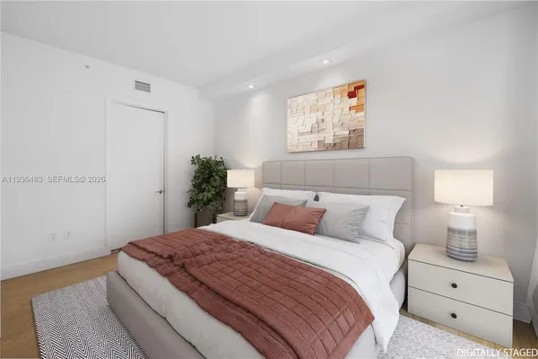 a bedroom with a bed and a painting on the wall