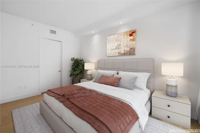 a bedroom with a bed and a painting on the wall