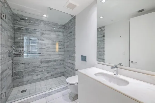 a bathroom with a sink mirror and a shower