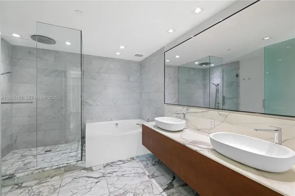 a bathroom with a tub sink and mirror