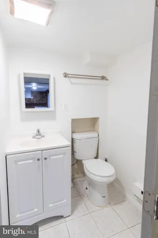 a bathroom with a toilet a sink and mirror