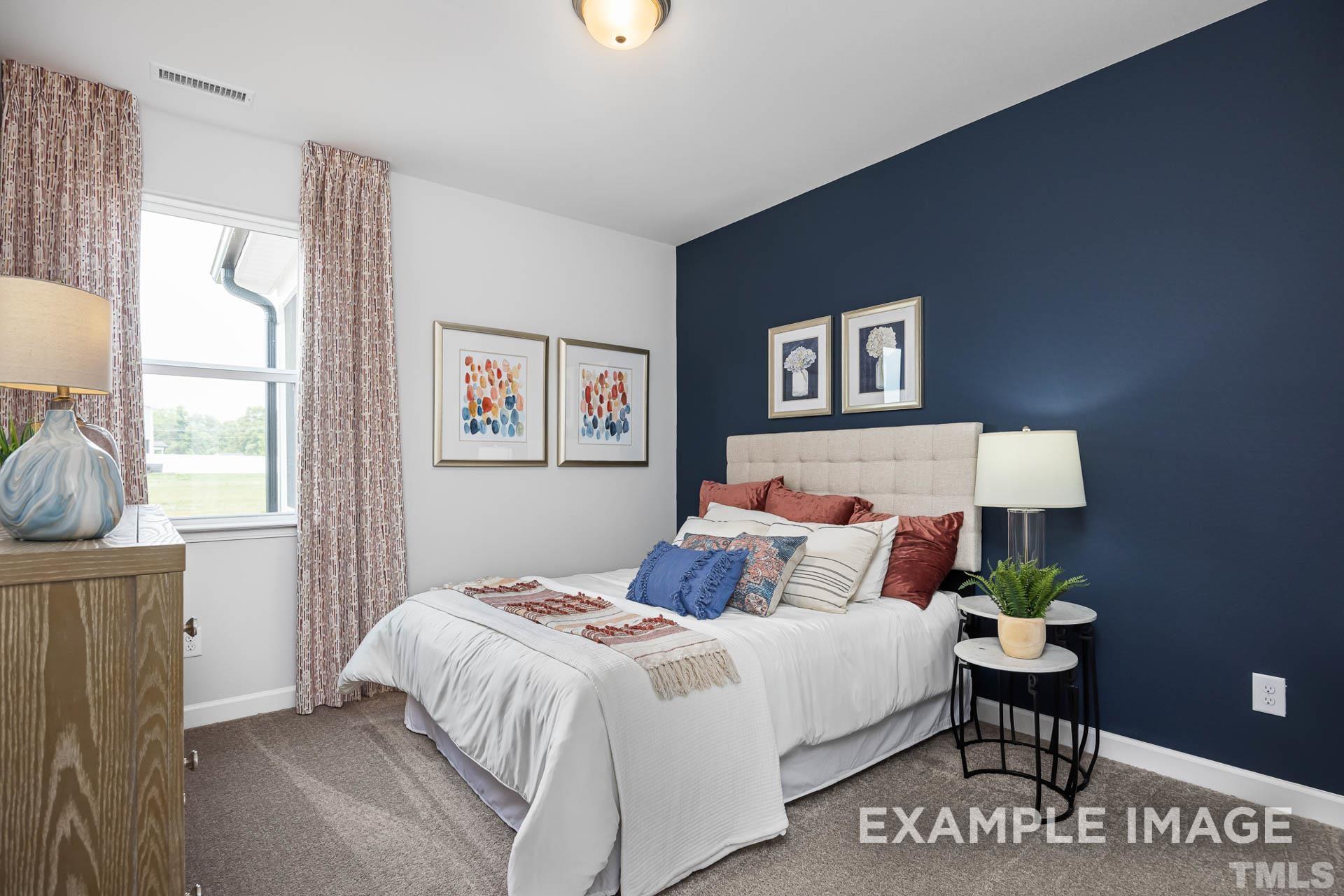 170 Rigsby Avenue Four Oaks, NC 27524 - Photo 20 of 39 a bedroom with a bed and a painting on the wall