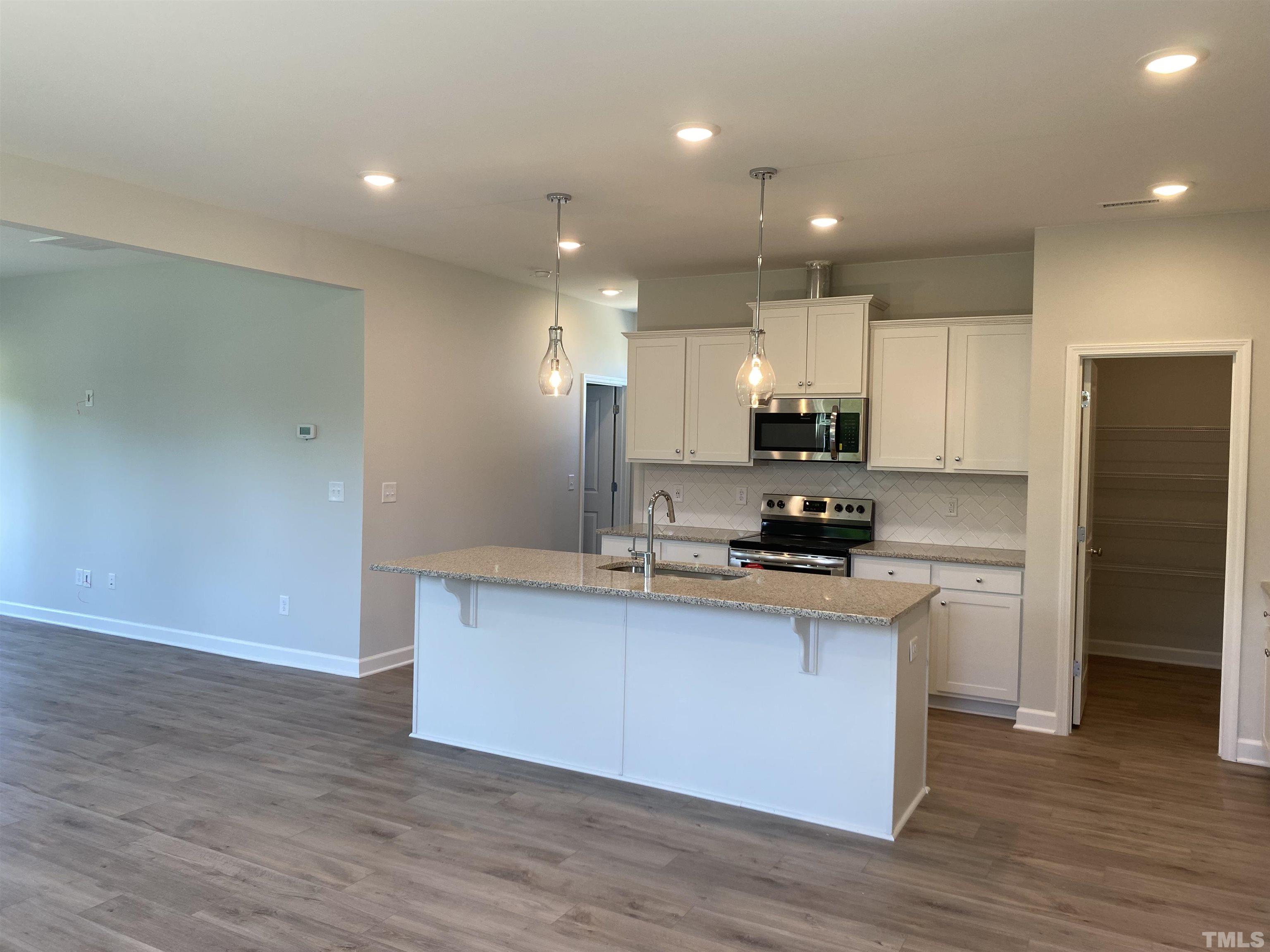 170 Rigsby Avenue Four Oaks, NC 27524 - Photo 2 of 39 a kitchen with stainless steel appliances granite countertop a sink a stove a refrigerator and cabinets