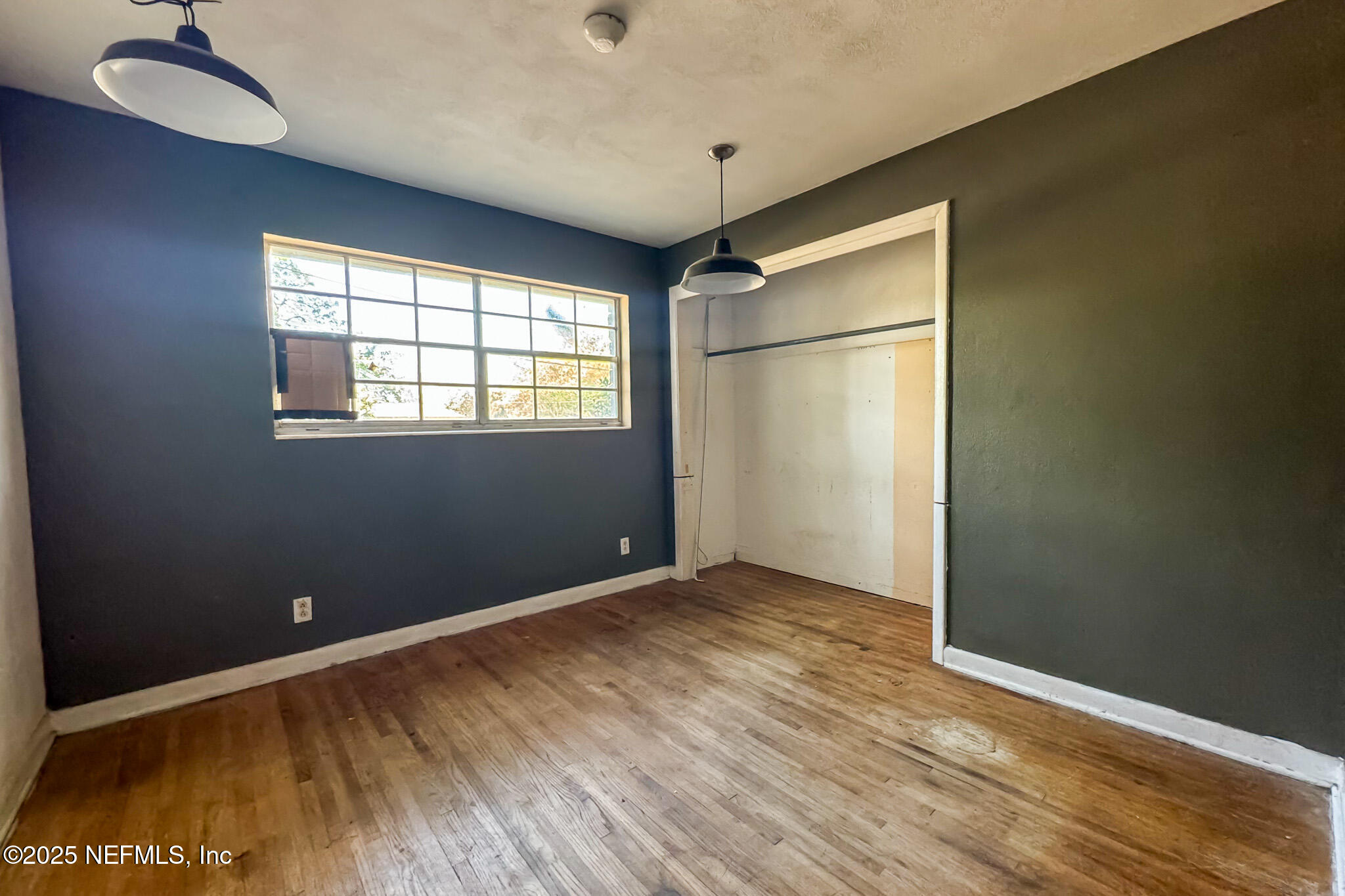 6537 Simca Drive Jacksonville, FL 32277 - Photo 7 of 26 an empty room with wooden floor and windows