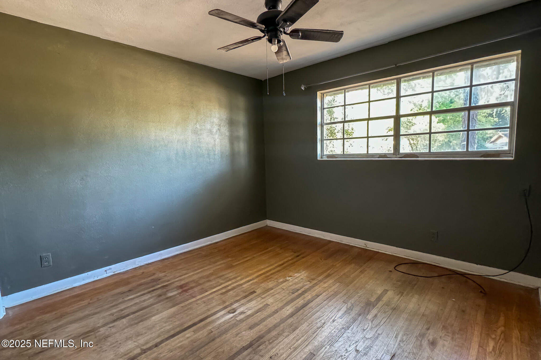 6537 Simca Drive Jacksonville, FL 32277 - Photo 8 of 26 wooden floor in an empty room with a window