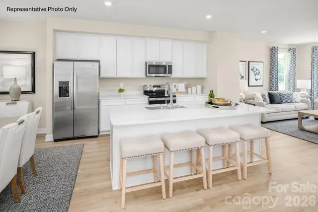 a kitchen with granite countertop a refrigerator and a stove top oven
