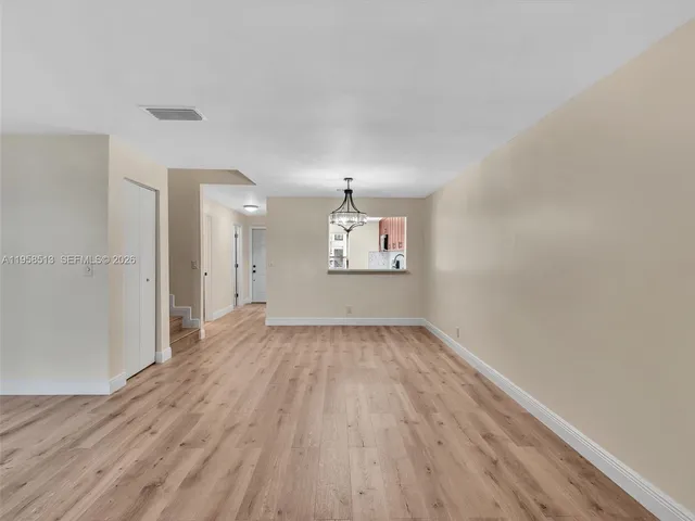 a view of a kitchen with stainless steel appliances cabinets and a wooden floor
