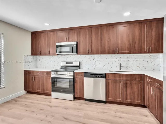 a kitchen with stainless steel appliances granite countertop a stove a microwave and a refrigerator