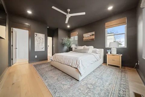 a spacious bedroom with a large bed and a chandelier