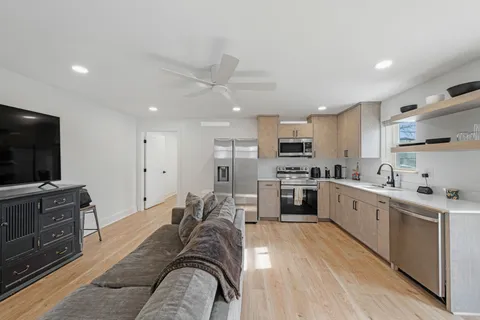 a large kitchen with stainless steel appliances lots of counter space a sink and a refrigerator