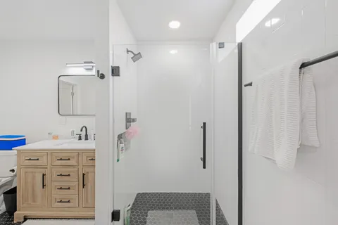 a bathroom with a sink vanity and shower