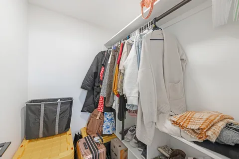 a view of walk in closet with clothes and shoes