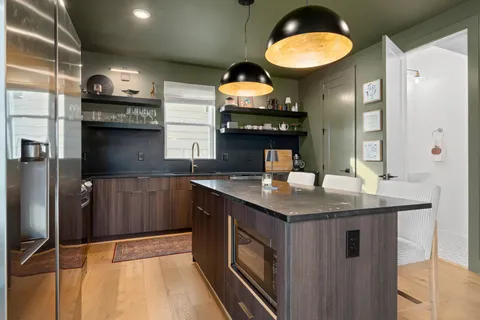 a kitchen with stainless steel appliances granite countertop a stove a sink and a microwave