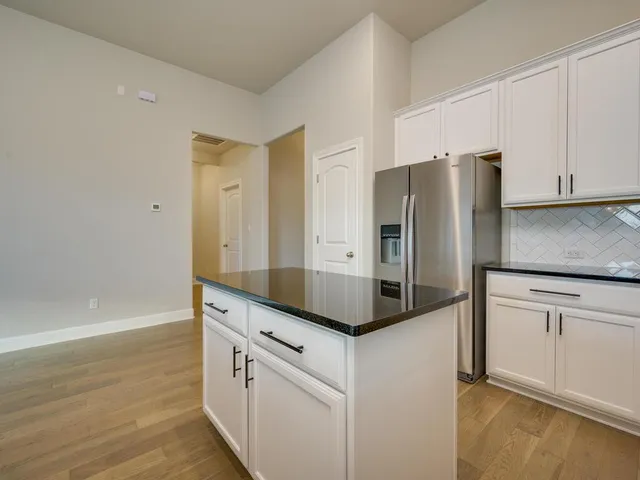 a kitchen with stainless steel appliances granite countertop a refrigerator and a stove