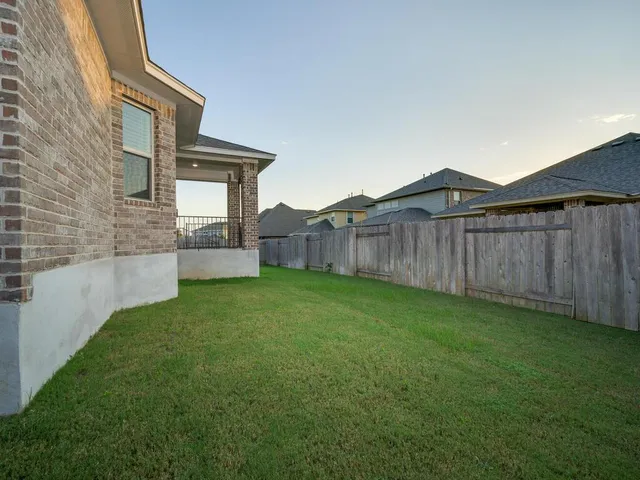 a view of a backyard with wooden fence