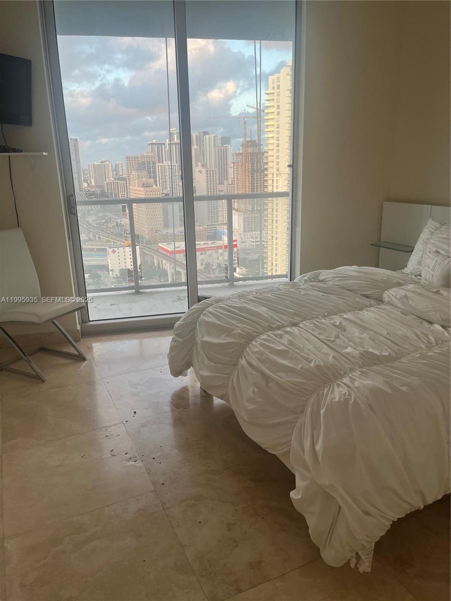 185 Southwest 7th Street, Unit 3211 Miami, FL 33130 - Photo 11 of 15 a bed sitting in a bedroom next to a window