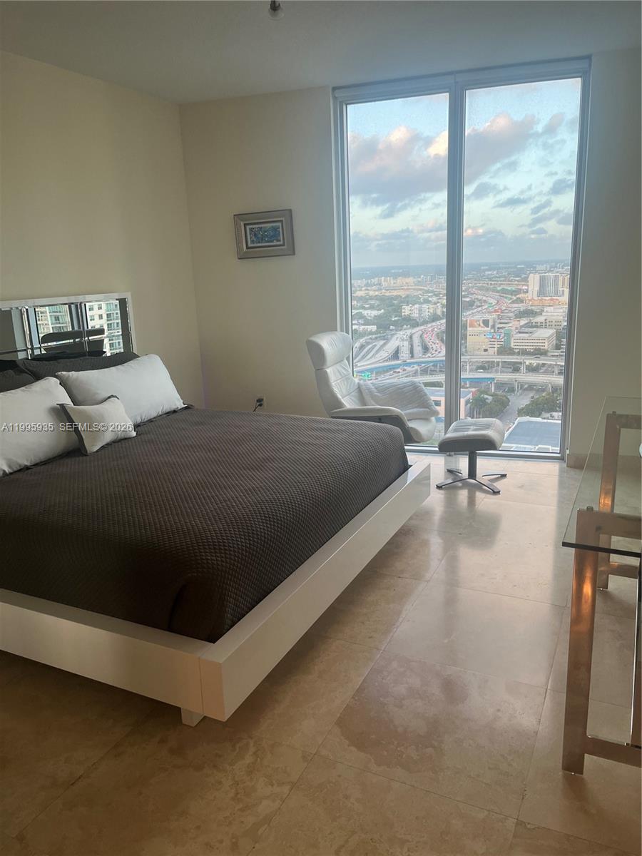 185 Southwest 7th Street, Unit 3211 Miami, FL 33130 - Photo 8 of 15 a bed sitting in a bedroom next to a window
