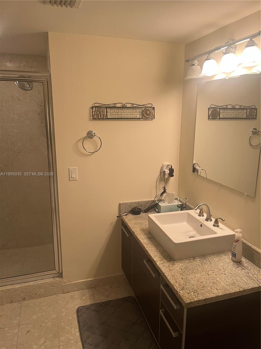 185 Southwest 7th Street, Unit 3211 Miami, FL 33130 - Photo 10 of 15 a bathroom with a granite countertop sink and a mirror