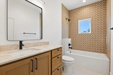 a bathroom with a granite countertop sink a toilet and a bathtub