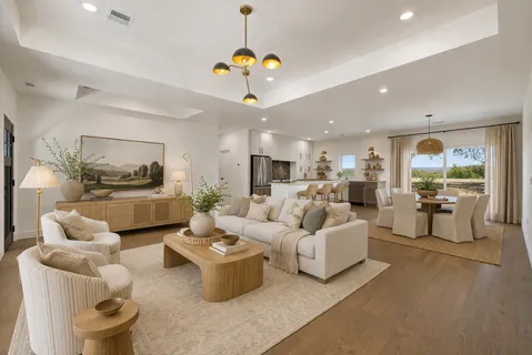 a living room with furniture kitchen view and a chandelier